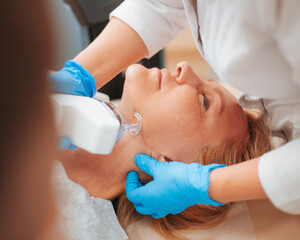 Doctor cosmetologist performs the procedure of laser skin resurfacing and scar removal with modern...