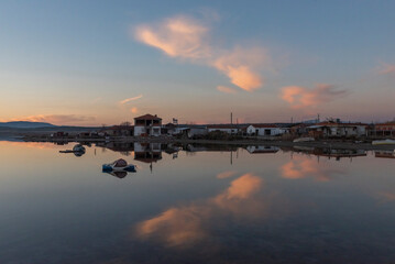 View of boats on sunset with reflection on the sea, colorful sky and clouds on sunset time with silhoutte of vehicles