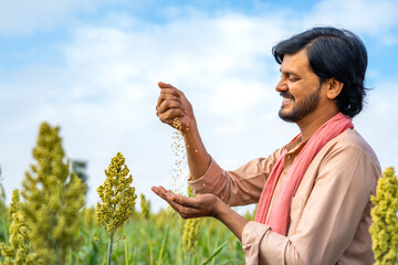 Happy smiling seeing seeds from recently grown crop at farmland showing with copy space - concept...