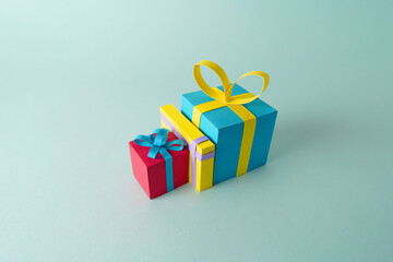 Paper cutout of isolated presents for birthdays, valentines day or Christmas over a minimalistic background, group of gifts with ribbon using papercraft art