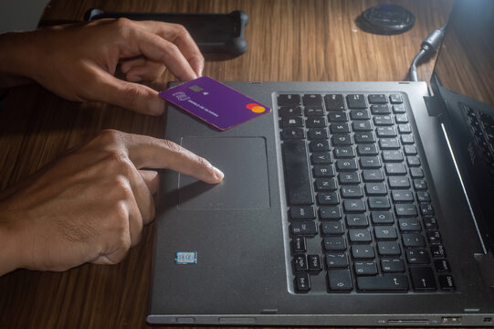 nubank card near a notebook brand dell with hand typing,home offce,editorial image ,campinas-sp,brazil-january,2022