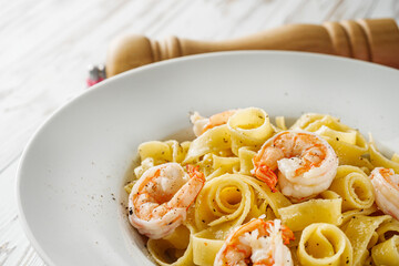 delicious shrimp fettuccine alfredo pasta on a white rustic background