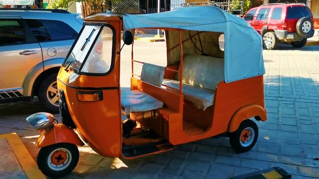 Orange tuk tuk white TukTuks rickshaw in Mexico.