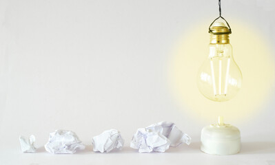 Fresh ideas or business transformation concept with crumpled paper balls and a light bulb, start up, success, teamwork and creativity business concept