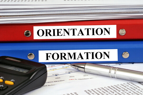 Dossiers orientation et formation empil&eacute;s sur un bureau