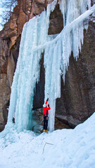 Coraggioso alpinista su cascata di ghiaccio