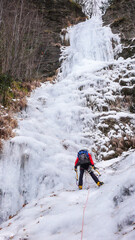 Coraggioso alpinista su cascata di ghiaccio.