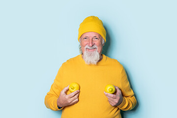 Excited senior man showing lemons and smiling