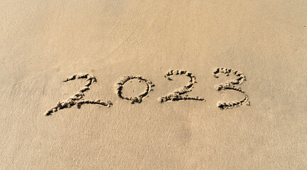 2023 hand written in sand on a beautiful beach