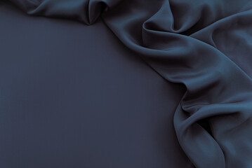 Dark blue silk satin background. Bright folds on a shiny fabric. Valentine's Day. Luxury background...