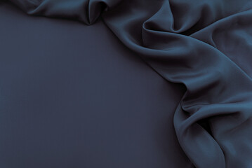 Dark blue silk satin background. Bright folds on a shiny fabric. Valentine's Day. Luxury background with empty space for design. Top view web banner