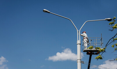 Men in cradle painting lamppost