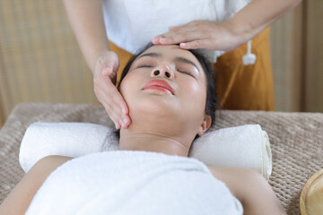 Fototapeta na wymiar Relaxed Asian woman receiving beauty massage in spa salon.