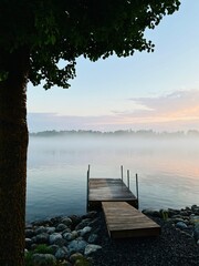 Tender fog at the lake, bright blue and purple sky, natural misty lake background