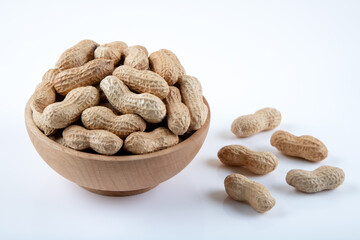 Bowl full of shelled peanuts on white background