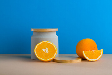 A front view of citrus decorated with wooden podium in blue background