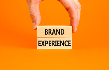 Brand experience symbol. Concept words Brand experience on wooden blocks. Beautiful orange table...
