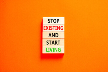 Stop existing start living symbol. Concept words Stop existing and start living on wooden blocks....