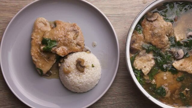 Turkey fillet cooking chop in sauce with green leaves