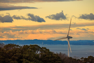 Coastal Wind Turbine with Beautiful Sunset Sky in Background - 564311228