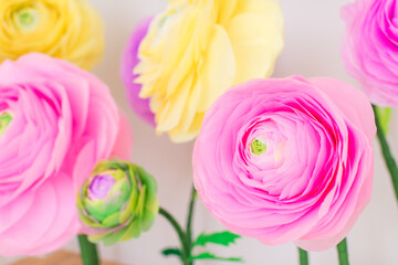 Fototapeta na wymiar Decorative paper ranunculus flowers in pastel colors, wedding decor