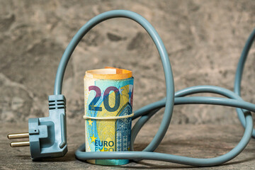 Naklejka premium Electric plug and roll of euro banknotes