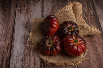 group of moorish tomatoes on a raffia cloth on a wooden table