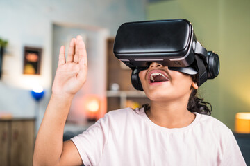 Smiling teenger girl kid with VR or virtual reality headset saying hi on video call on metaverse at home - concept of immersive experience and modern technology