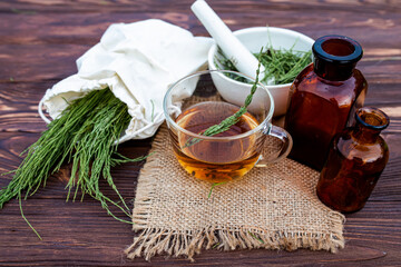 cup of tea from horsetail, made from fresh potion, from pharmacy mortar. Horsetail infusions are...