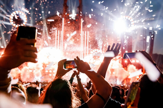 Making video of concert using a smartphone. Cheering people on an amazing music show.