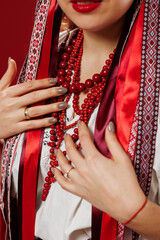 Close up of ukrainian woman in traditional ethnic clothing on viva magenta studio background. Ukrainian national embroidered dress call vyshyvanka. Pray for Ukraine