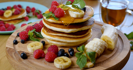 Sweet honey pouring over pancakes. Tasty breakfast food