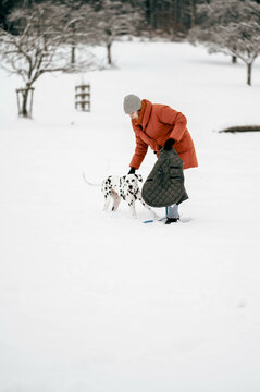 frau mit Hund (Dalmatiner) im Schnee