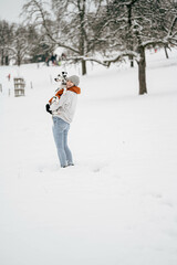 Fototapeta na wymiar Frau posiert mit Hund im Schnee während Winter
