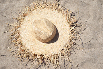 Straw hat on the sandy beach. View from above.