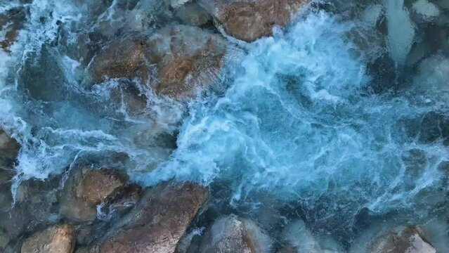 A wild mountain river with crystal clear water. Well water is flowing over stones. aerial view 4 K