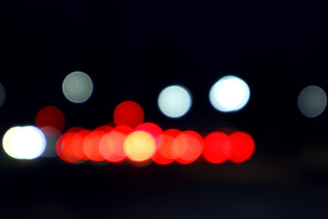   Dark background of colorful bokeh from blurred car headlights