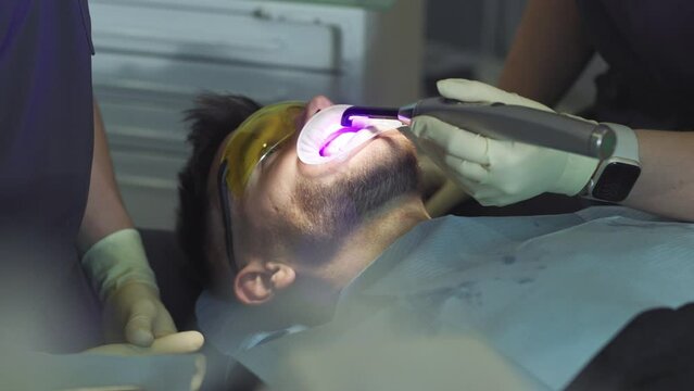 Close up the patient treating the teeth. Hands dentist and assistants hold a dental instrument. Hydience and healthy. Modern clinic