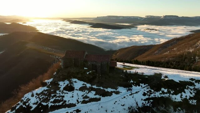 4k aerial view Hermitage in Kolitza mount in Balmaseda at dawn with snow, Basque Country, Spain