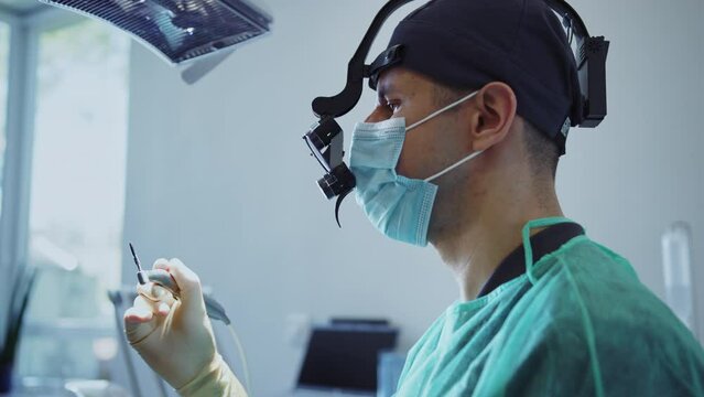 In modern clinic dentist with special eye in medical mask holds dental instrument that treats teeth. Hydience and healthy
