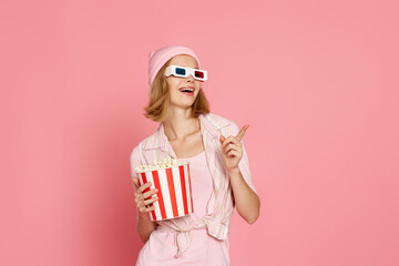 woman in t-shirt and hat with popcorn pointing at the copy space