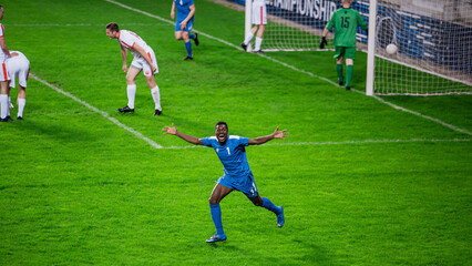 Championship Match: Blue Soccer Football Team Attack, Player Run Happy after Scoring Goal, Celebrate Victory, Looks at the Camera. Sport Channel Broadcast Television Concept.