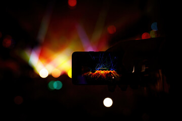 Smartphone in the hand of a music fan at the concert.