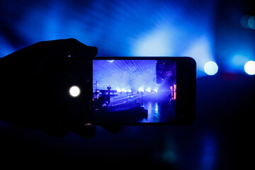 Smartphone in the hand of a music fan at the concert.