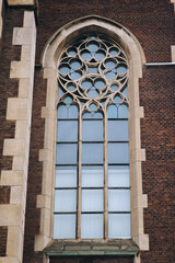 Fototapeta premium Elongated lafge vintage vertical window on the facade of the ancient building. Baroque and Gothic architecture. Church of St. Olga and Elizabeth. Lviv, Ukraine.