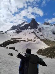 Fototapeta na wymiar Himachal, India - June 9th, 2022 : Active hiker enjoying the view of Himalayas in Hampta Trek