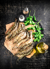 Raw shrimp on paper with spices and parsley. 