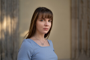 portrait of a young woman in blue dress, standing on a sunny day