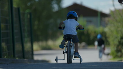 Small boy riding bicycle outside child rides bike wearing helmet