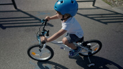 Little boy riding bicycle wearing helmet